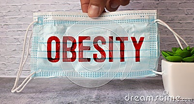 OBESITY word on blue medical mask, concept Stock Photo