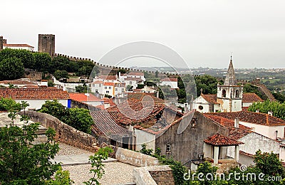 Beautiful tiny cobblestoned streets, walls, and roofs in Obidos Stock Photo