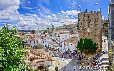 Obidos, Portugal. Cityscape of the town with medieval houses, wall and the Albarra tower Editorial Stock Photo