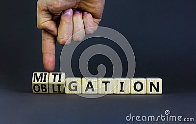 Obligation and mitigation symbol. Businessman turns wooden cubes changes the concept word obligation to mitigation. Beautiful grey Stock Photo