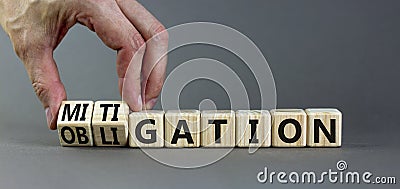 Obligation and mitigation symbol. Businessman turns wooden cubes changes the concept word obligation to mitigation. Beautiful grey Stock Photo
