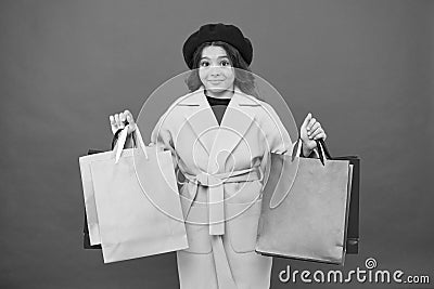 Obsessed with shopping. Girl cute kid hold shopping bags red background. Get discount shopping on birthday holiday Stock Photo