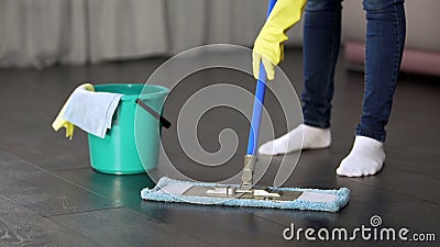 Obsessive with cleanliness young lady thoroughly washing floor of her house Stock Photo