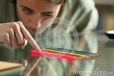 Obsessive compulsive woman aligning up pencils on a table Stock Photo