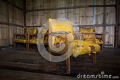 obsolete old yellow leather chair in abondon house Stock Photo