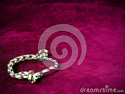 Five colored string on a purple red background. Stock Photo