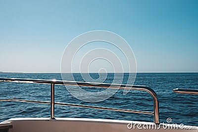 Ocean and blue sky / sea view horizon behind boat railing Stock Photo