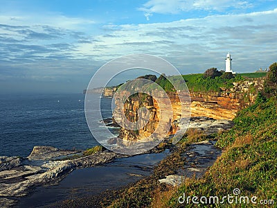 Ocean Cliffs With a White Lighthouse Stock Photo