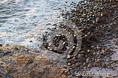 Ocean lapping on pebbles and rocks Stock Photo