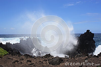 Ocean spray from large waves crashing into lava rock on the shore of Laupahoehoe Point on the island of Hawaii Stock Photo