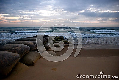 Ocean Sunrise with Sandbags Stock Photo