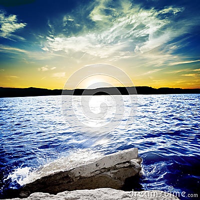 Ocean waves breaking on a rock with sunset Stock Photo