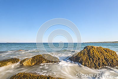 Ocean waves lash line impact rock on the beach Stock Photo