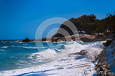 Ocean waves roll over a narrow strip of sandy beach in Lamai, Koh Samui, Thailand. A deserted part of Paradise beach. Stock Photo