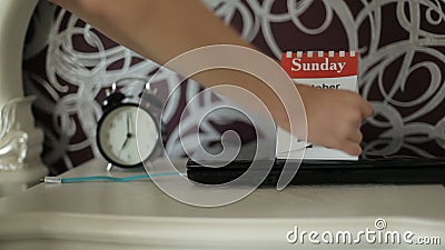 Ochtend van een bedrijfsvrouw Ochtendstudent De vrouwelijke hand knipt het kalenderblad weg Ochtend van een bedrijfsvrouw Ochtendstudent De vrouwelijke hand knipt het kalenderblad weg