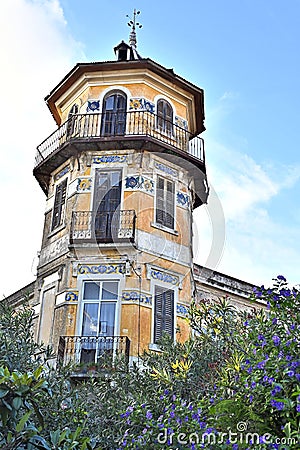 Octagonal tower with four floors, tiled friezes on facades, balconies and wrought iron railings. Stock Photo