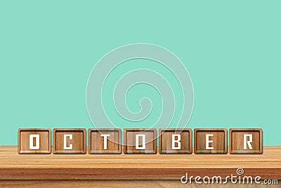 October alphabet blocks on wooden table with blue background Stock Photo