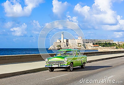 American green 1952 vintage car on the promenade Malecon and in the background the Castillo de los Tres Reyes Stock Photo