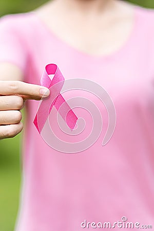 October Breast Cancer Awareness month, adult Woman in pink T- shirt with hand holding Pink Ribbon for supporting people living and Stock Photo