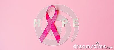 October Breast Cancer Awareness month, Pink Ribbon with HOPE text on pink background for supporting people living and illness. Stock Photo