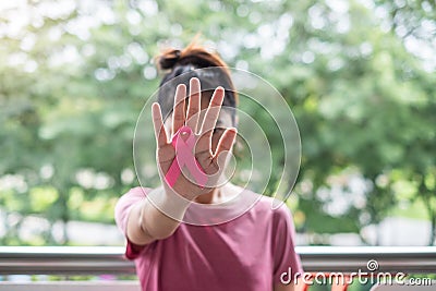 October Breast Cancer Awareness month, Woman in pink T- shirt with hand holding Pink Ribbon for supporting people living and Stock Photo