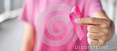 October Breast Cancer Awareness month, Woman in pink T- shirt with hand holding Pink Ribbon for supporting people living and Stock Photo