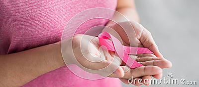 October Breast Cancer Awareness month, Woman in pink T- shirt with hand holding Pink Ribbon for supporting people living and Stock Photo