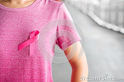 October Breast Cancer Awareness month, Woman in pink T- shirt with Pink Ribbon for supporting people living and illness. Stock Photo