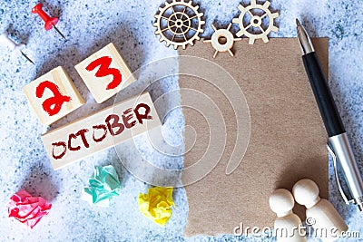 October 23 - Daily colorful Calendar with Block Notes and Pencil on wood table background, Stock Photo