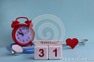 October 31. Day of the 31th month, calendar date. White wooden calendar blocks with date, clock and stethoscope on blue pastel Stock Photo