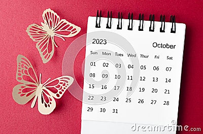 A October 2023 desk calendar for the organizer to plan and reminder with paer butterfly on red background Stock Photo