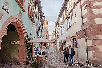 People sightseeing in beautiful French village and enjoy outdoor restaurants. Editorial Stock Photo