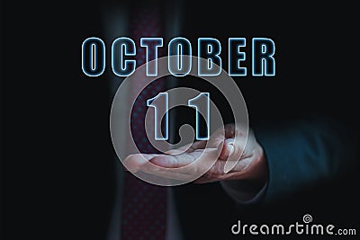 october 11th. Day 11 of month, announcement of date of business meeting or event. businessman holds the name of the month and day Stock Photo