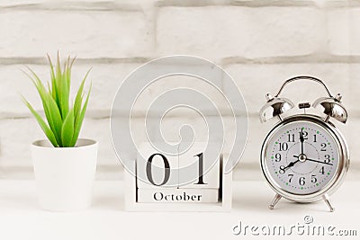 October 1 on the wooden calendar next to the alarm clock, the start date of the new month Stock Photo