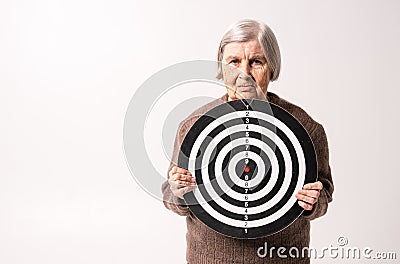 Octogenarian old lady holding target in her wrinkled hands Stock Photo