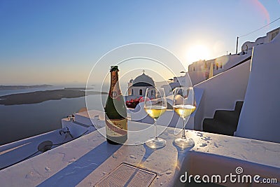 Two champagne glasses on the edge of infinity swimming pool at sunset, Santorini island. Editorial Stock Photo