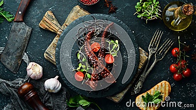 Octopus tentacles baked in garlic sauce and black pasta with cuttlefish ink. Luxury restaurant food. Seafood. Stock Photo