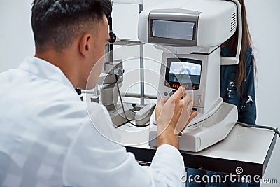Oculist tests vision of patient by using special modern machine Stock Photo
