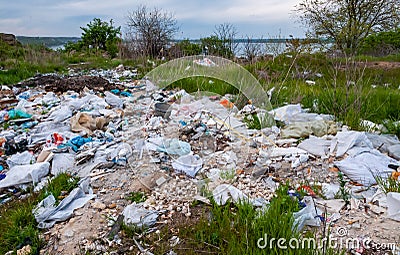 Heaps of plastic trash on the shore of the reservoir. Ecology of nature Editorial Stock Photo