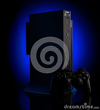 Odessa, Ukraine - April 14, 2020. The legendary vintage Playstation 2 game console on a dark back with a light blue spot. Sony PS2 Editorial Stock Photo
