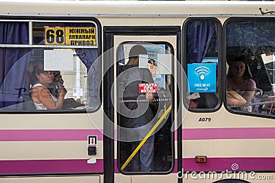 ODESSA, UKRAINE - AUGUST 13, 2015: Passengers looking out of the window of a marshrutka Editorial Stock Photo