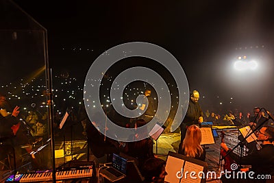 Odessa, Ukraine-circa 2019: Dark background Bright lights music show. Rock concert and Symphony orchestra. Conductor, musical Editorial Stock Photo