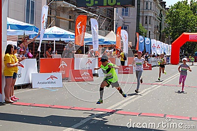 Marathon runners kids cross finish line at sunny summer day Editorial Stock Photo