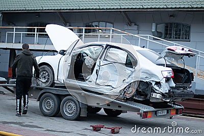 Odessa, Ukraine - March 11th 2020: Tow truck loads white smashed car after traffic accident Editorial Stock Photo