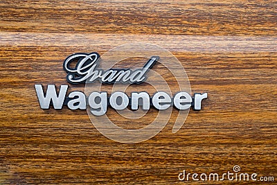 Off-road Jeep Grand Wagoneer logo on wooden background presented on annual oldtimer car show, Israel Editorial Stock Photo