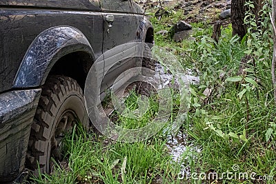 Off-road vehicle stuck in the mud. Dirty offroad car in swamp. Adventure travel concept. 4x4 SUV got bogged. Journey, tourism Stock Photo