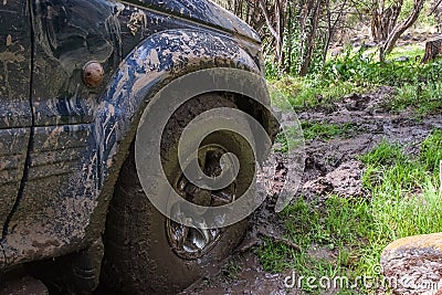 Off-road vehicle stuck in the mud. Dirty offroad car in swamp. Adventure travel concept. 4x4 SUV got bogged. Journey, tourism Stock Photo