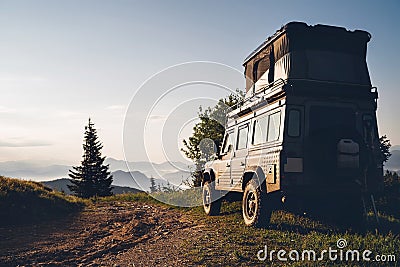 Off-road 4x4 with pop top elevating roof sleeping tent storage vehicle on the dirty country road in the Slovakian mountains in the Stock Photo