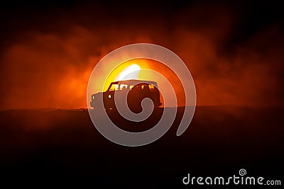 Off roader jeep silhouette on dark toned foggy sky background. Car with light at night. Stock Photo