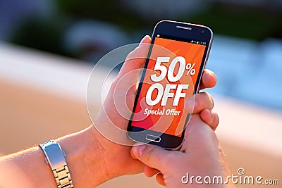 50% OFF Sale. Smartphone with a 50% discount advertising on screen. Stock Photo